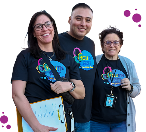 Three smiling adults wearing ‘Youth Fest’ t-shirts, standing together and holding drinks
