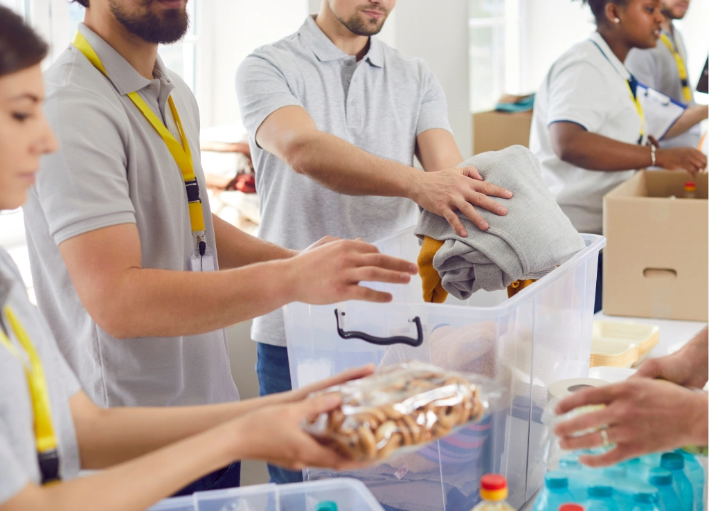 Caucasian and African American volunteers preparing supplies for refugee shelters