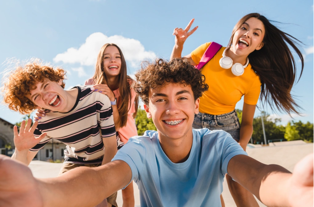 Group of smiling teenagers taking a selfie outdoors