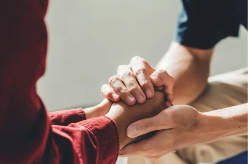 Man holding a woman's hand as a symbol of support and care